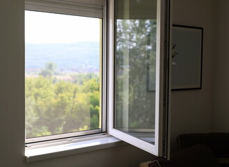 Naklejka na ściany i meble Open window with nature landscape view from inside house, apartment interior