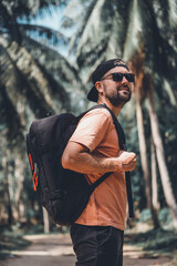 Travel beard man posing in the palms road, travel blogger, backpack black, hat, sneakers, shorts style, outdoor hipster portrait, sunglasses, Thailand