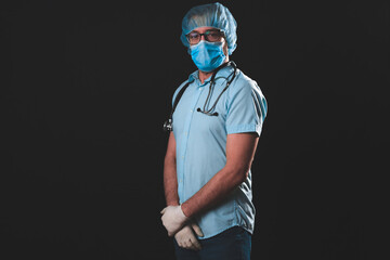 Medical doctor, nurse, surgeon, psychologist working with protective mask, glasses and gloves helping people in the days of panic, pandemic - studio shot on black background.