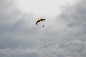 Paraglider with motor and parachute. Flying man on a paraglider.