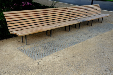 wooden long park bench with curved backrest anatomical wooden cladding made of light wood on the...