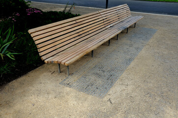 wooden long park bench with curved backrest anatomical wooden cladding made of light wood on the...