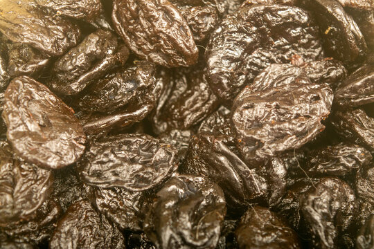 Dried prunes in bulk. Surface texture. Close up.