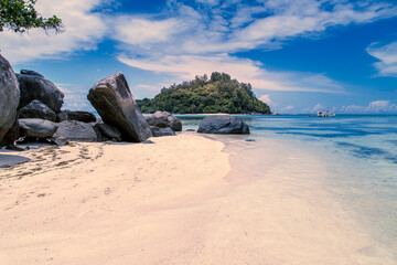 Tropical and heavenly beach with blue sky, coconut trees, white sands, crystal clear waters,...