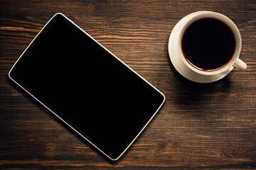 Tablet and coffee cup on wooden table