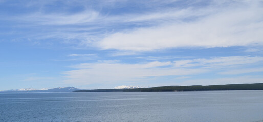 Obraz premium Late Spring in Yellowstone National Park: Looking Across Yellowstone Lake to Channel Mountain, Overlook Mountain, Barlow Peak, Mount Hancock, Flat Mountain and Mount Sheridan of the Red Mountains