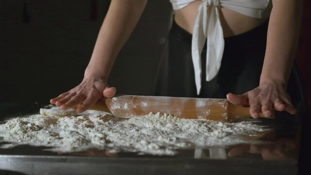 Attractive adult woman making chebureks - Georgian national dish. Process of making food, cooking at the kitchen. Raw cheburek.