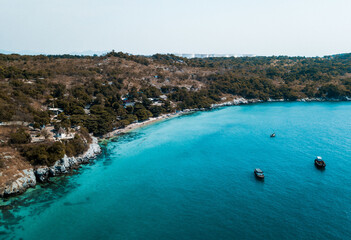 Drone shot of an small and beautiful blue and crystal clear beach at Koh Sichang, an island close to Bangkok, Thailand
