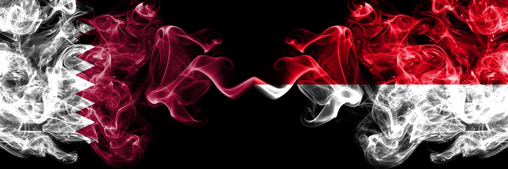 Fototapeta premium Qatar vs Monaco, Monacan smoky mystic flags placed side by side. Thick colored silky abstract smoke flags.