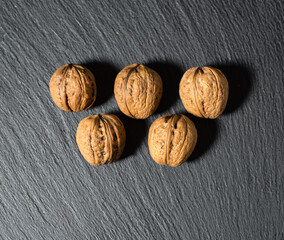 Whole walnuts on a black textured background