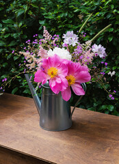 summer bouquet of blooming peonies and wildflowers