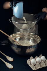 Woman in checkered apron add wheat flour to raw yeast dough. Process of making bakery. Adjarian Khachapuri Recipe – Georgian cheese bread.