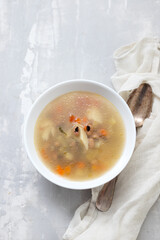 fish soup in white bowl on ceramic background