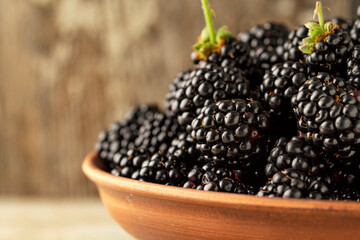 Close-up of fresh blackberries in a bowl on rustic table