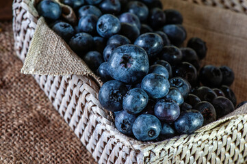 Ripe blueberries in a wicker basket close-up, selective focus