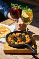 cabbage rolls stuffed with meat and rice in a cast-iron pan and lemonade. on the terrace table on a bright sunny day