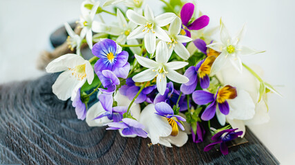 beautiful bouquet of delicate wild flowers anemones and violets on an old wooden Board. Close-up, selective focus