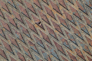 Close-up of a weathered diamond steel plate. Weathering has produced beautiful rust to blue-gray variations. Diamond pattern is angled.