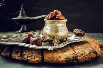 antique vase of dates on a large silver tray. Festive composition of Ramadan Kareem.