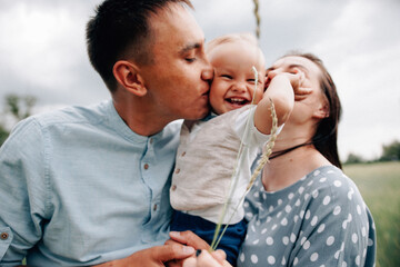 A happy family walks with a child in nature