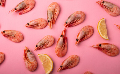 Shrimp and sliced lemon on a bright pink background. Pattern. The view from the top.