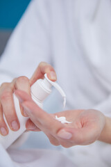 Young woman applying hand cream at home, closeup