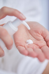 Young woman applying hand cream at home, closeup