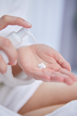 Young woman applying hand cream at home, closeup