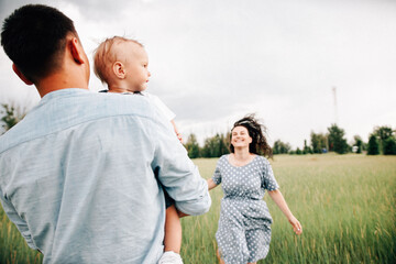 A happy family walks with a child in nature