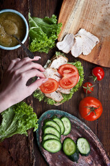 assembling sandwich with turkey meat, fresh tomatoes, cucumbers and green salad, nobody