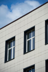facade of a modern building on a bright Sunny day, siding and Windows, beautiful exterior of the new building