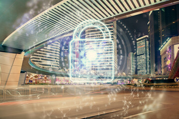 Lock icon hologram on city view with skyscrapers background multi exposure. Data security concept.