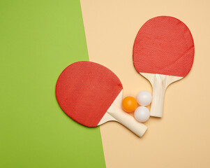 two wooden rackets and an orange plastic ball for playing table tennis