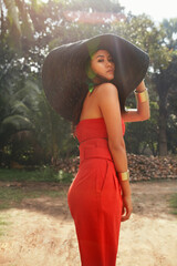Summer fashion. Beautiful asian woman model in stylish red clothes, sun hat at tropical nature....