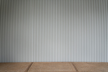 empty scene of rattan bench with white corrugated wall in minimal modern style apartment / residential interior concept / copy space