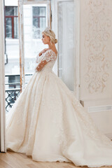 Bride in white dress, blonde girl posing in a photo studio. Vintage style interior.