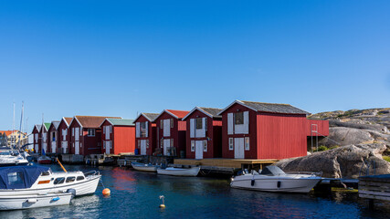 Fototapeta na wymiar Typical Swedish west coastal environment with red boathouses, bridges and happy summer guests enjoying the perfect weather.