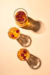 White wine sangria with nectarine and raspberries in glasses and a decanter on light background. Top view layout.