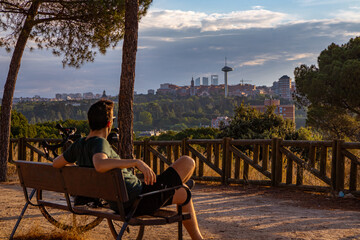 Ciclista descansa mirando el horizonte de Madrid