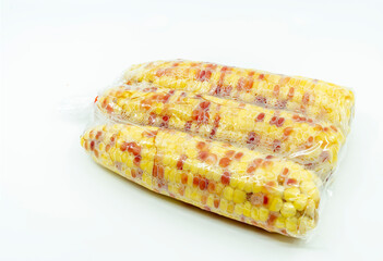 Boiled organic sweet corn or waxy corn for sell in cleared plastic bag. Image boiled waxy corn in cleared plastic bag on white background.