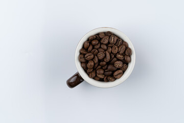 Blue mountain coffee beans in a cup, top view on white background, advertisement photo with text space