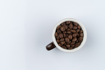 Balinese coffee beans in a cup, directly above, isolated on white