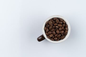 Balinese coffee beans in a cup, directly above, isolated on white