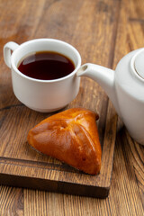 Russian triangle stuffed bun with tea