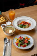 Lunch in a cafe: summer salad, pasta and mushroom cream-soup