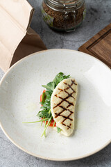 Open sandwich made on grilled halloumi and stuffed with rocket and tomatoes