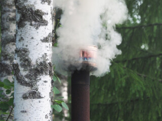 thick smoke comes from the chimney. forest