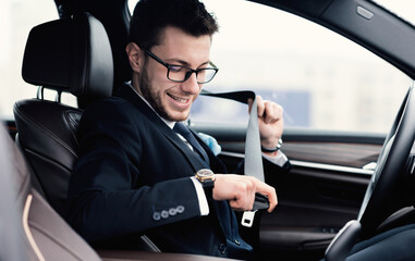Man In Glasses Putting On Seat Belt