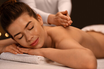 Obraz na płótnie Canvas Closeup of tranquil woman enjoying relaxing massage at spa