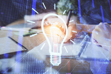 Drawing bulb over woman's hands taking notes background. Concept of idea. Double exposure